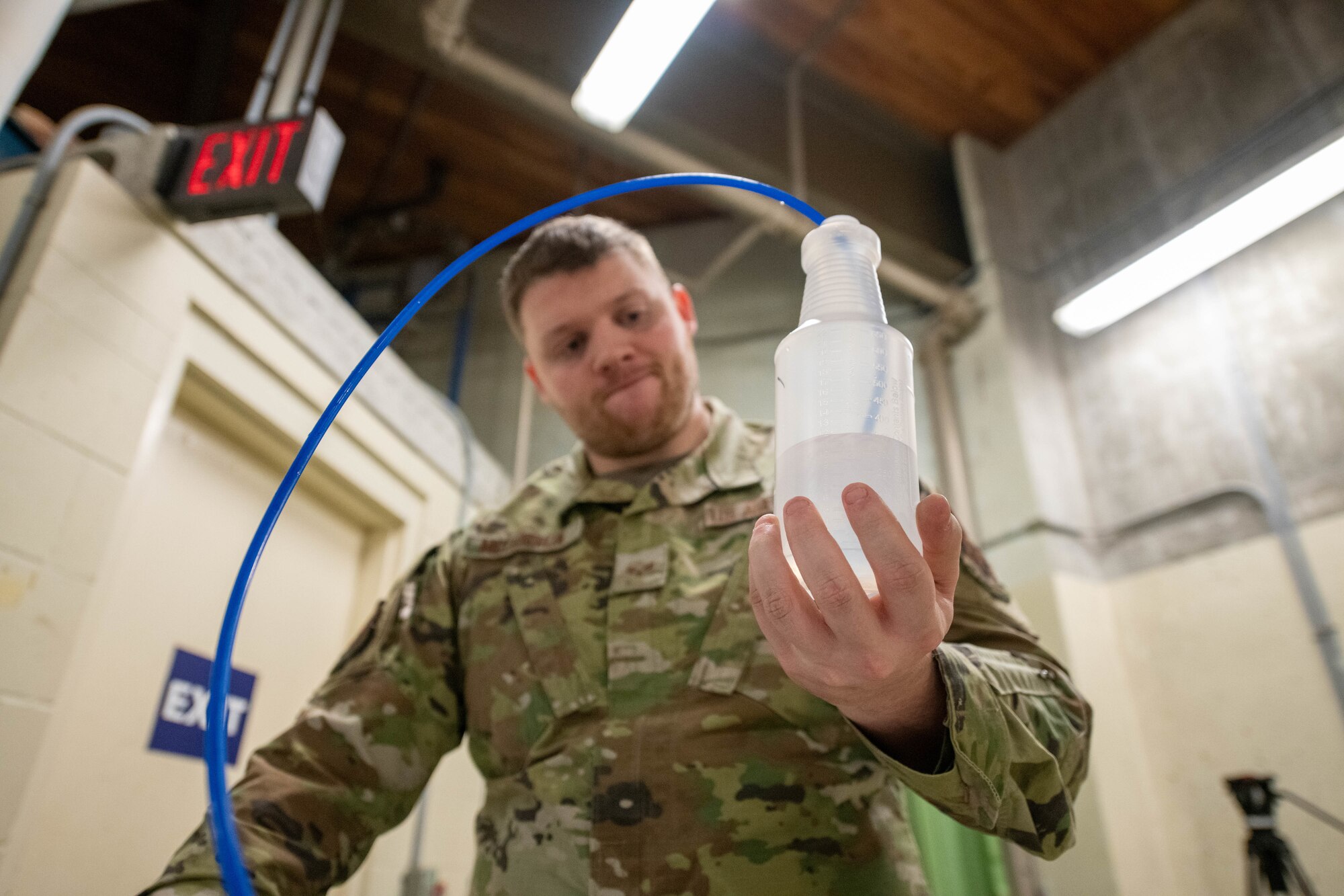 Man looks at bottle containing freshwater.