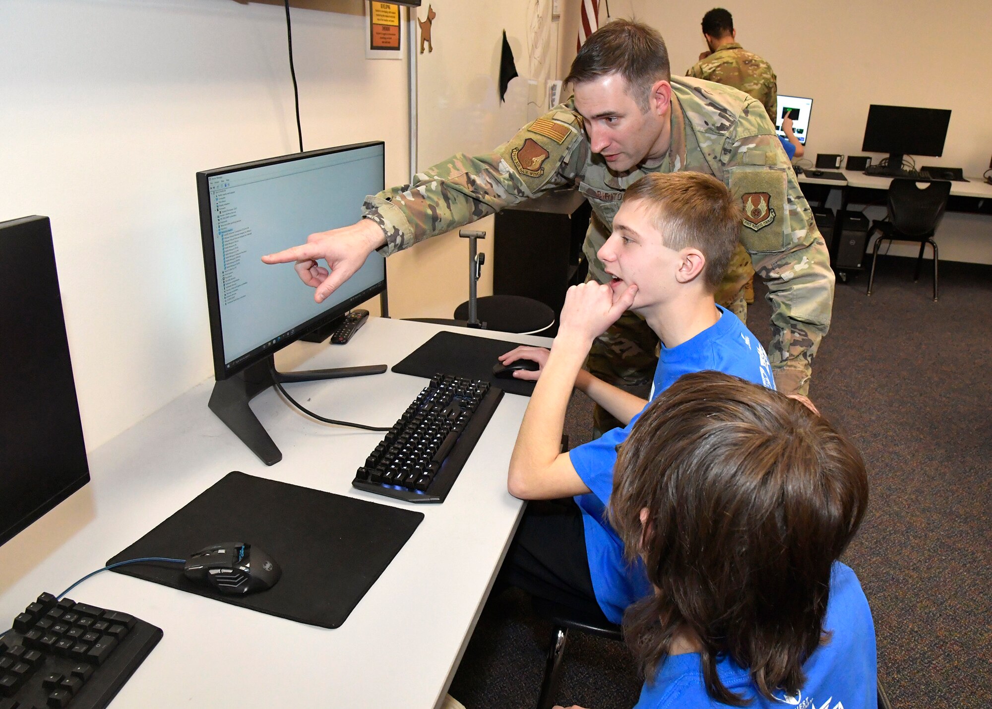 Master Sgt. Jarred Dirito, Flight Chief network infrastructure, 75th Communication and Information Directorate, reviews an image with students Feb. 14, 2024, at Quest Academy Charter School in West Haven, Utah. The student team recently competed in the National Youth Cyber Defense Competition, the nation's largest that puts middle and high school students in charge of securing a simulated virtual network. The middle school team placed first in the state of Utah this year, which was in the top 11% nationally of the state finals competition and in the top 15% nationally in the national semi-finals.