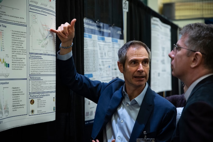 Dr. Mike Goodson, left, research biologist, Air Force Research Laboratory, or AFRL, 711th Human Performance Wing, and Anthony Malanoski, right, chemical engineer, Naval Research Lab, discuss research on submariners and gut biomes during the poster session at the AFRL Biotech Days Summit Feb. 27, 2024, at Wright-State University in Dayton, Ohio. More than 275 people attended the two-day event, which included presentations highlighting the lab's early to mid-stage technologies, and featured demonstrations and various speakers. (U.S. Air Force photo / Richard Eldridge).