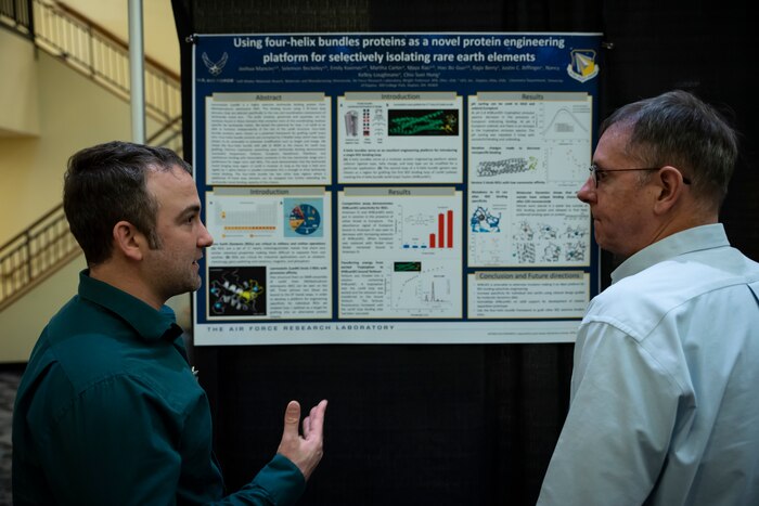 Air Force Research Laboratory, or AFRL, Materials and Manufacturing Directorate contractor Joshua Mancini, left, and Peter Mirau, right, AFRL senior materials engineer, discuss research on rare earth magnets during the poster session at the AFRL Biotech Days Summit Feb. 27, 2024, at Wright-State University in Dayton, Ohio. More than 275 people attended the two-day event, which included presentations highlighting the lab's early to mid-stage technologies, and featured demonstrations and various speakers. (U.S. Air Force photo / Richard Eldridge).