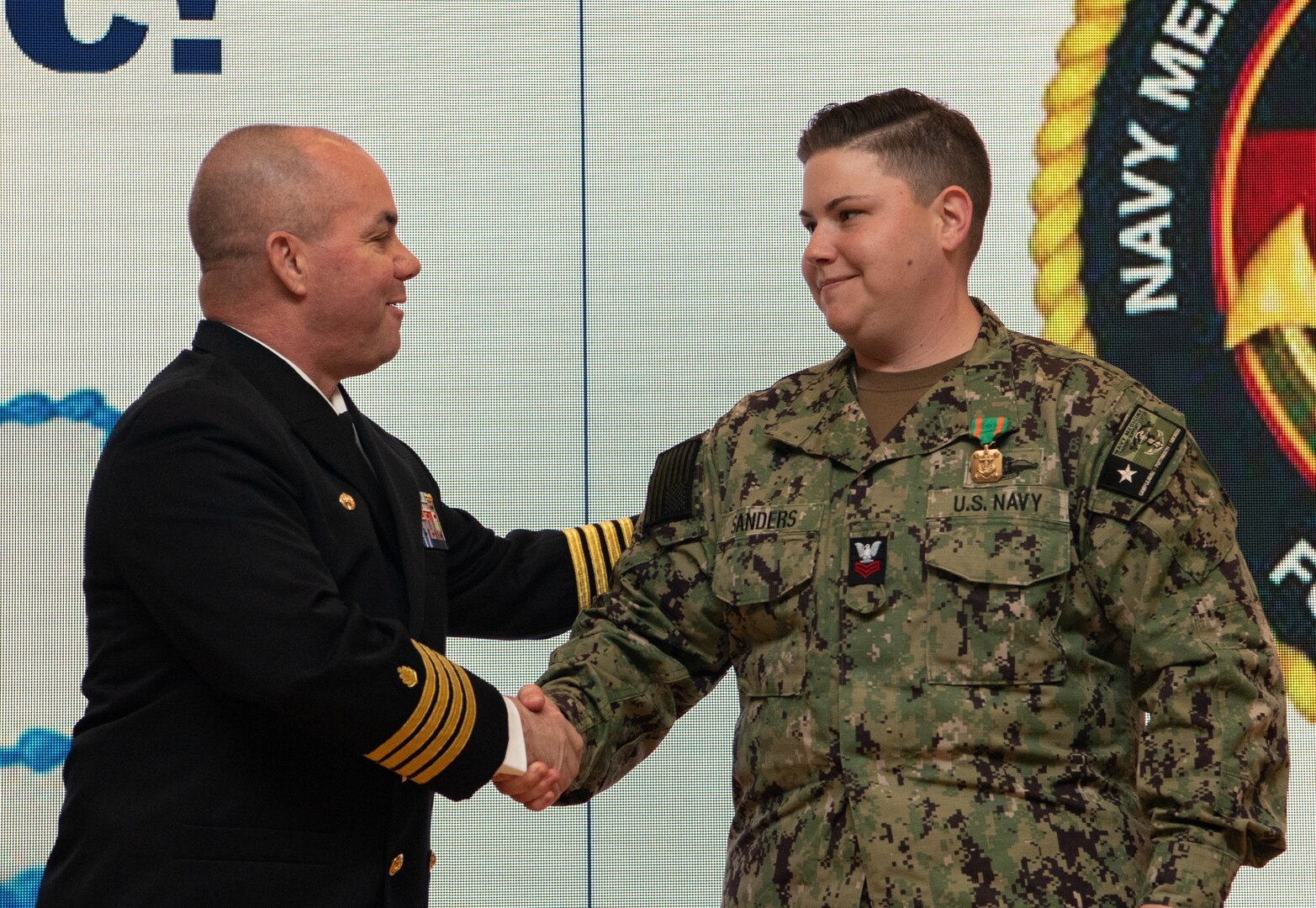 240229-N-DQ752-1015 JOINT BASE SAN ANTONIO FT. SAM HOUSTON, Texas (Feb. 29, 2024) Capt. Paul Allen, commander, Navy Medicine Training Support Center (NMTSC),  presents Religious Program Specialist 1st Class Amber Sanders, leading petty officer of the religious ministry team at NMTSC, with a Navy and Marine Corps Achievement Medal during a ceremony in Anderson Hall Feb. 29. NMTSC is the Navy component command that provides administrative and operational control over Navy staff and students assigned to the Medical Education and Training Campus and other medical programs in the San Antonio area. (U.S. Navy Photo by Mass Communication Specialist 2nd Class Cheyenne Geletka/Released)