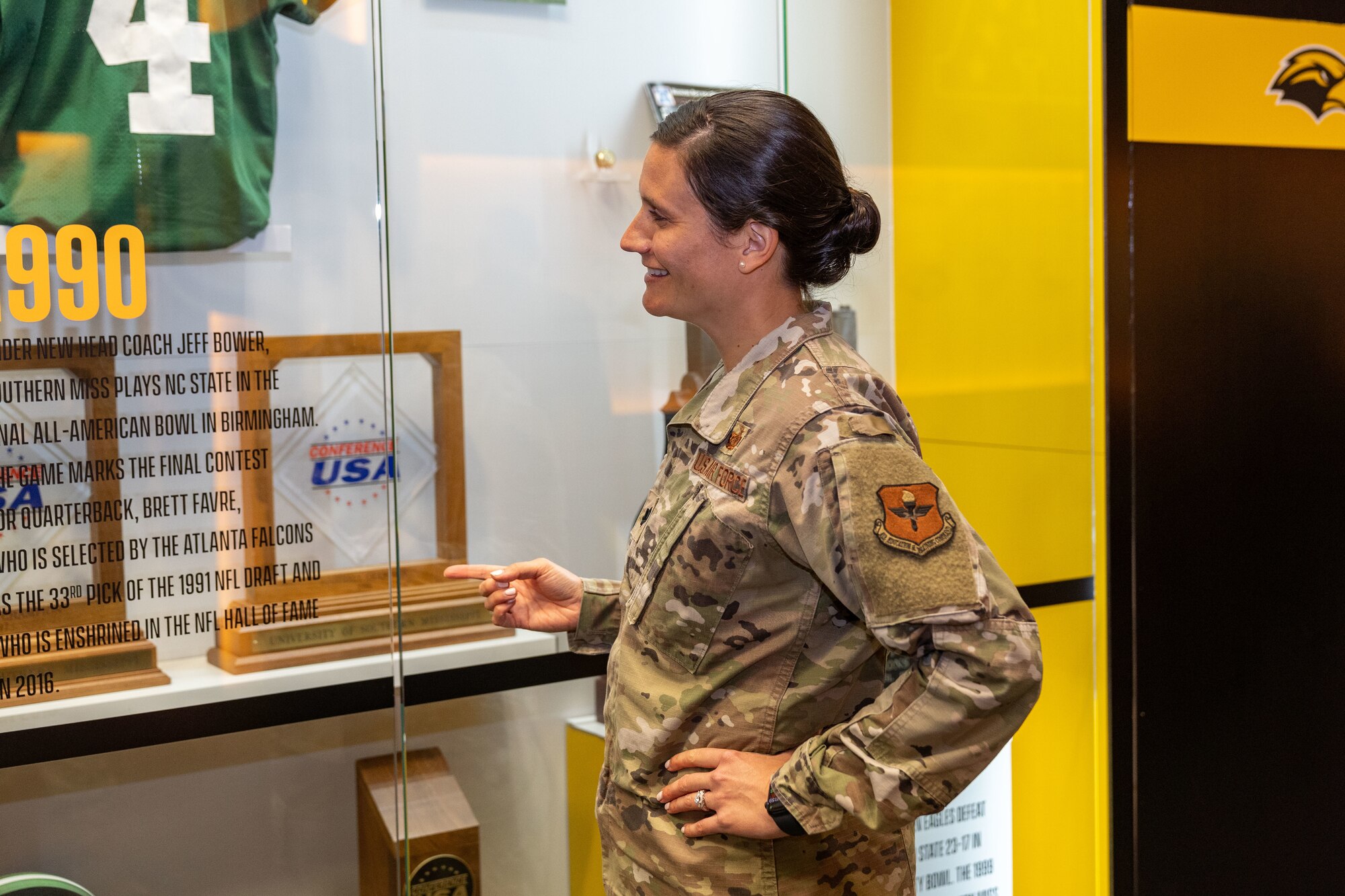 U.S. Air Force Lt. Col. Katherine Kuc, 81st Force Support Squadron commander, looks at a display of a football player and University of Southern Mississippi alumni in Hattiesburg, Mississippi, March 1, 2024.