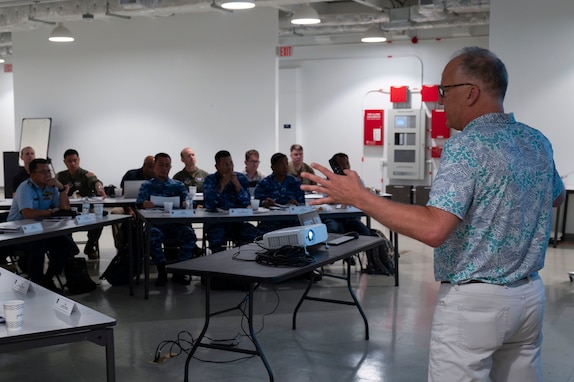 Kevin Palko, briefs participants of the Regional Air Domain Awareness Senior Leader Seminar on Andersen Air Force Base, Guam, Feb. 26, 2024. Throughout the seminar, leaders discussed air domain strategies, policies, terminology and also developed a network of Allies and partners that have a shared understanding of air domain awareness. (U.S. Air Force photo by Airman 1st Class Spencer Perkins)