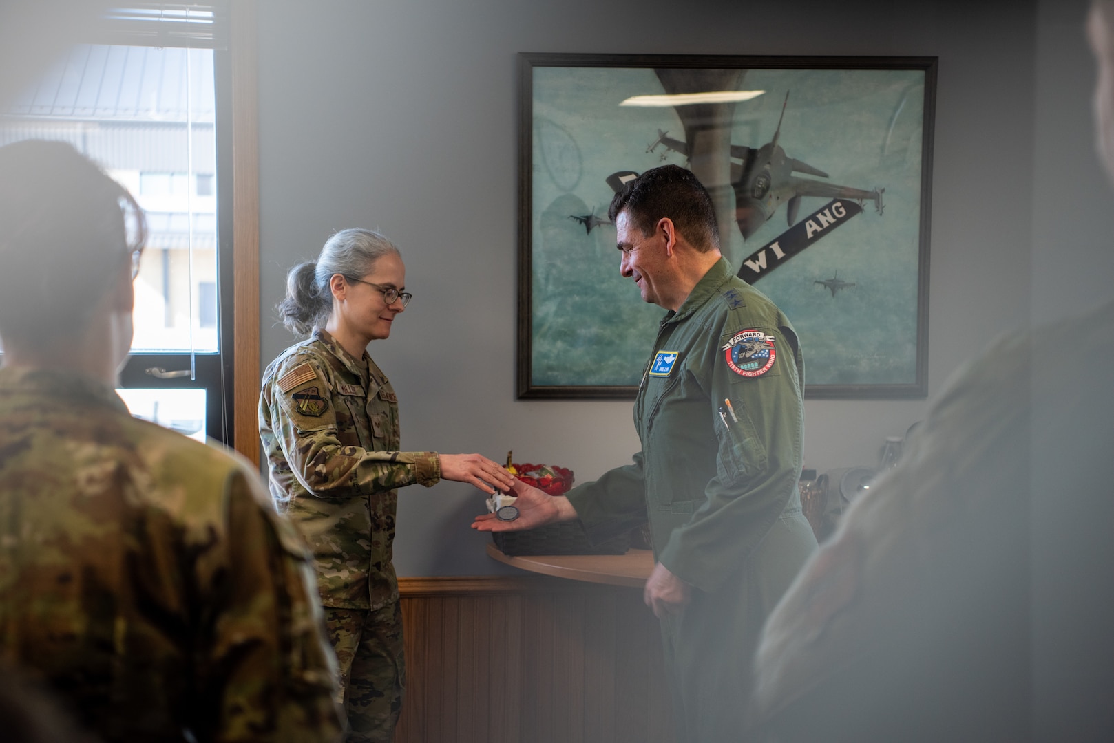 Senior Airman Margaret A. Miller receives a coin from Lt. Gen. Michael A. Loh, director, Air National Guard, at the 128th Air Refueling Wing, Milwaukee, Wisconsin, March 3, 2024. Miller is a part of the 128th ARW medical group and was recognized for exceptional personnel processing that ensured maximum Airmen readiness across the wing.