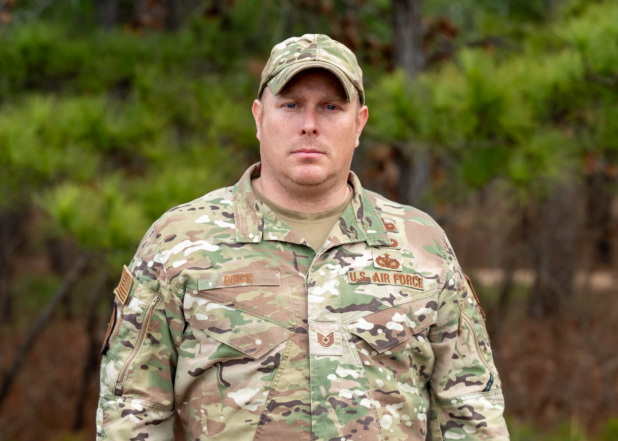 A man stands in front of trees for a portrait.