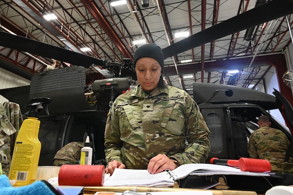 Cpl. Marquita Chase, avionic mechanic, District of Columbia Army National Guard Aviation, reviews a manual prior to maintenance on a UH-60 Blackhawk at Davison Army Airfield, Feb. 3, 2024.  DCARNG Aviation is comprised of four different units with women visibly represented in all sections to include pilots, maintainers, supply, operations, administration, and flight paramedics.
