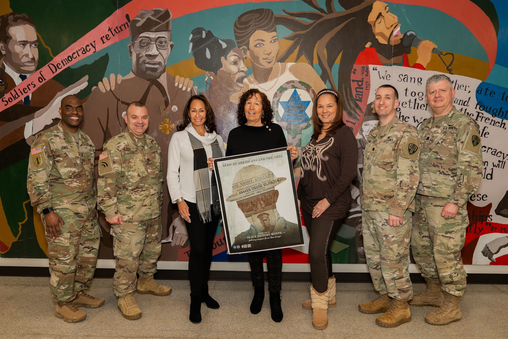 The granddaughters of legendary Harlem Hellfighter James Reese Europe — Patricia Europe Pearson, Lynn Europe Cotter, and Theresa Europe — pose with senior officers of the 369th Sustainment Brigade for a photo in front of a mural during a visit to the Harlem Regiment Armory in New York Feb. 24, 2024. They were given a tour of the armory by New York Army National Guard Command Sgt. Maj. Leyland Jones, Col. Patrick Clare, and Lt. Cols. David Myones and Peter Fish.