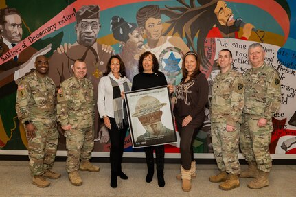 The granddaughters of legendary Harlem Hellfighter James Reese Europe — Patricia Europe Pearson, Lynn Europe Cotter, and Theresa Europe — pose with senior officers of the 369th Sustainment Brigade for a photo in front of a mural during a visit to the Harlem Regiment Armory in New York Feb. 24, 2024. They were given a tour of the armory by New York Army National Guard Command Sgt. Maj. Leyland Jones, Col. Patrick Clare, and Lt. Cols. David Myones and Peter Fish.