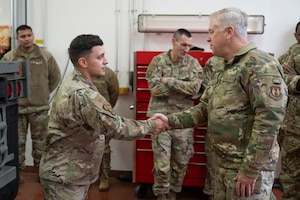 U.S. Air Force Maj. Gen. John Allen, right, Air Force Installation and Mission Support Center commander, coins U.S. Air Force Master Sgt. Devin Mazza, 52nd Logistics Readiness Squadron Air Force Forces Transportation Training Center-Europe instructor, at Spangdahlem Air Base, Germany, Feb. 8, 2024.