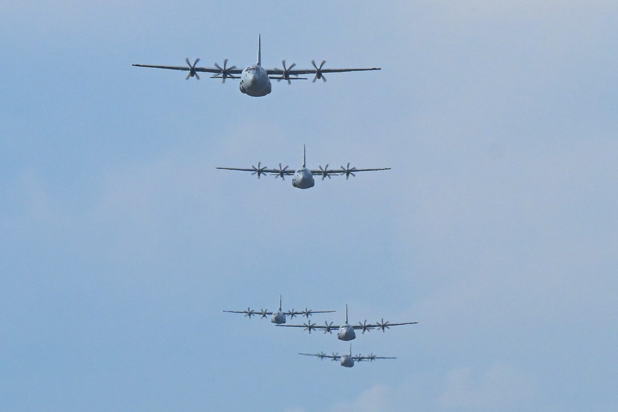 A C-130 flies through the sky.