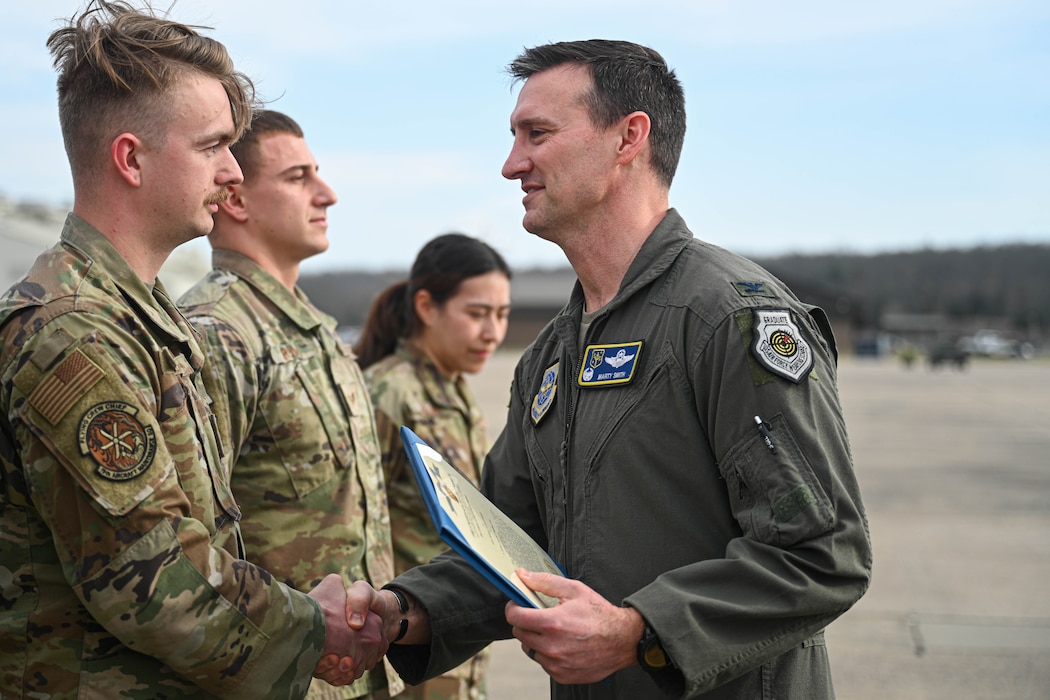 Staff Sgt. Bryson Niehaus, 41st Airlift Squadron flying crew chief, accepts a coin for their performance during a recent maximum endurance operation at Little Rock Air Force Base, Arkansas, Feb. 26, 2024. During the operation, two C-130J Super Hercules from the 41st Airlift Squadron conducted a roughly 30-hour single-aircraft maximum endurance mission demonstrating multi-day mission generation capabilities while only landing to refuel.
