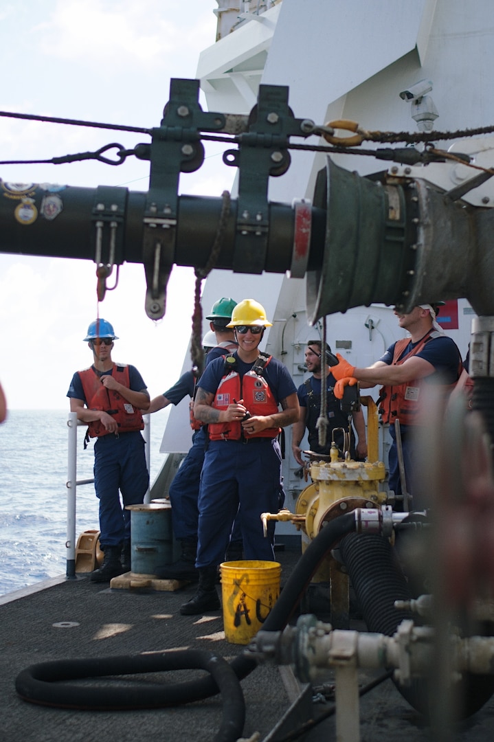 Petty Officer 1st Class Bianca Valenzuela stands ready on the fueling deck of U.S. Coast Guard Cutter Bertholf (WMSL 750) during a refueling at sea evolution with U.S. Naval Ship John Ericsson (T-AO 194) on Feb. 23, 2024, in the South China Sea. Alongside connected replenishment is a standard method of transferring liquids such as fuel and water, allowing cutters to stay at sea uninterrupted for longer periods of time. (U.S. Coast Guard photo by Chief Petty Officer Oliver Fernander)