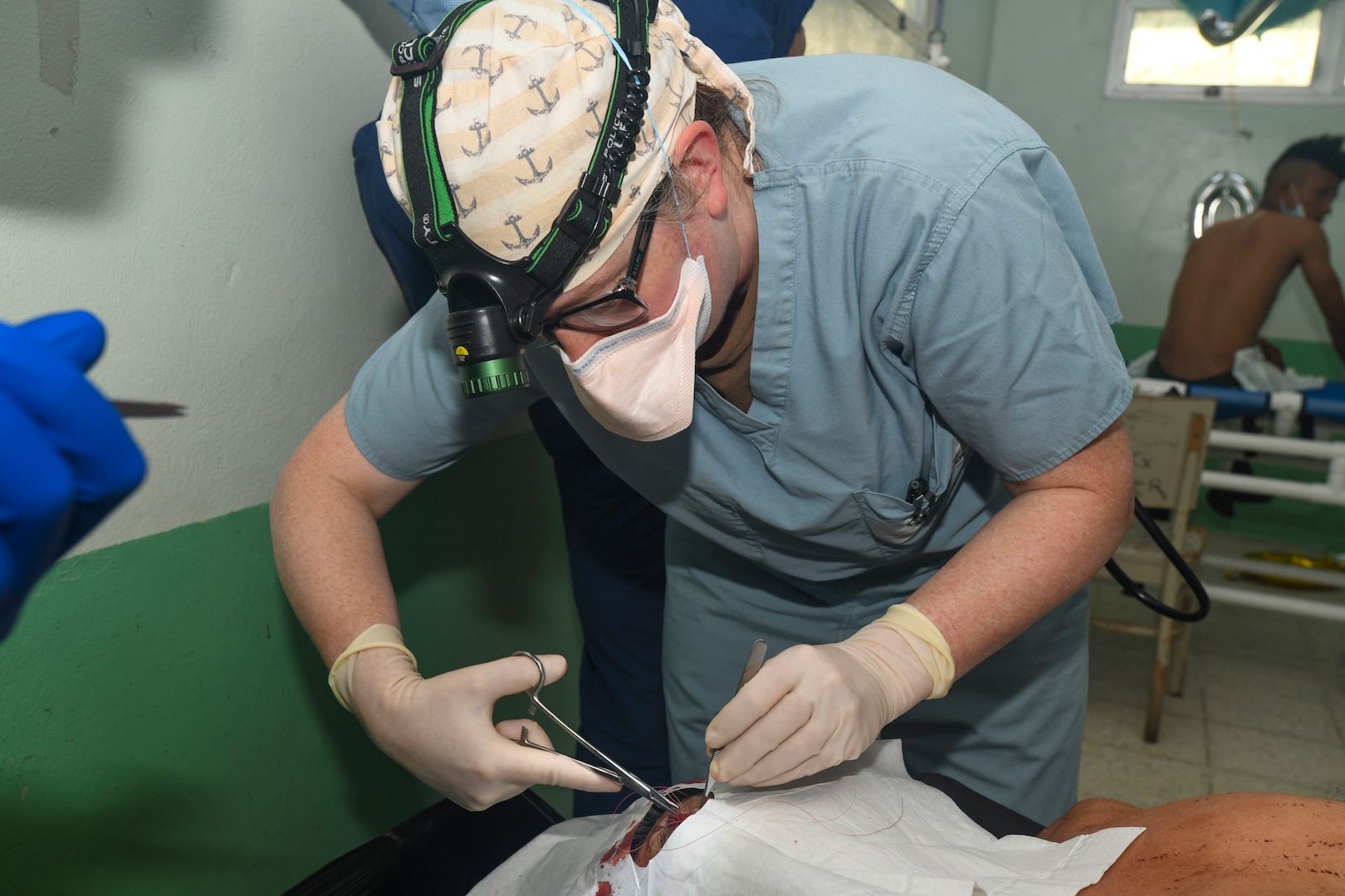 240227-N-FB730-1121 SAN PEDRO SULA, HONDURAS (Feb. 27, 2024) Capt. Jamie Fitch, a general surgeon with Expeditionary Resuscitative Surgical System (ERSS) 11 from Navy Medicine Readiness and Training Command Camp Lejeune, sutures a head laceration in the trauma bay at Hospital Nacional Mario Catarino Rivas, San Pedro Sula, Honduras on Feb. 27, 2024. In collaboration with joint forces and the host nation, Expeditionary Medical Unit 10 G conducted its first Global Health Engagement in Honduras enhances expeditionary core skills and exchanges knowledge with Honduran healthcare professionals in a limited resource environment. (U.S. Navy photo by Mass Communication Specialist 2nd Class Justin Woods)