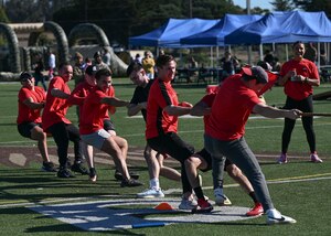 Members celebrate after a victory in tug-of-war on a football field.