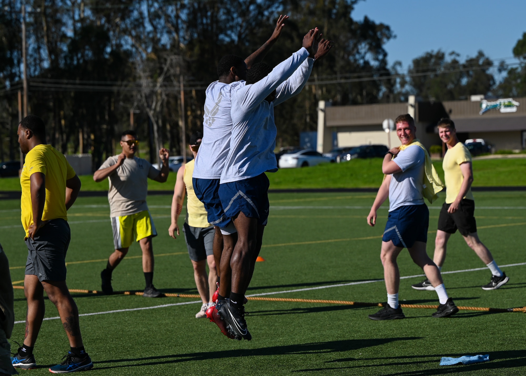 Members celebrate after a victory in tug-of-war on a football field.
