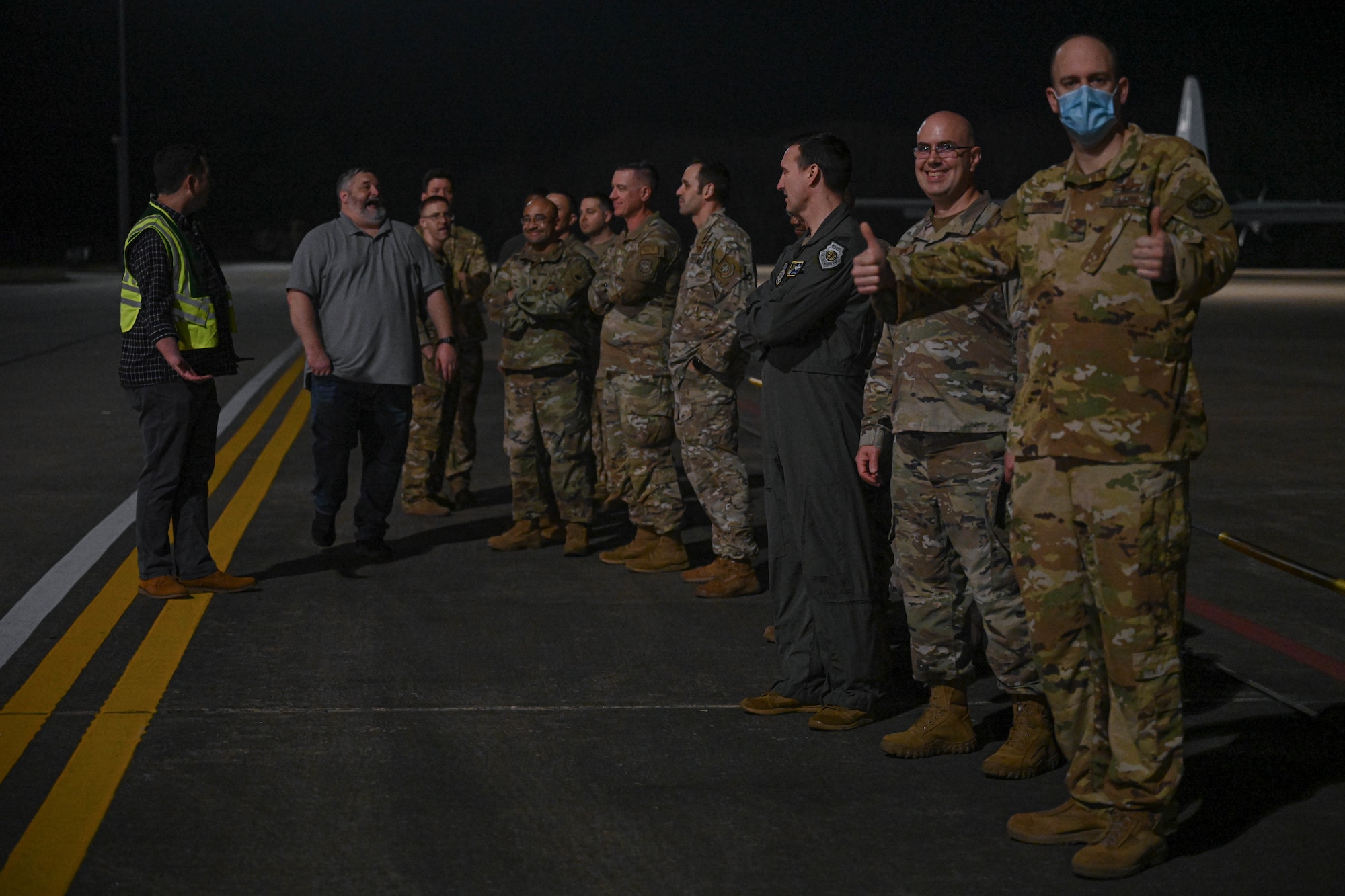 Airmen stand on the flightline.