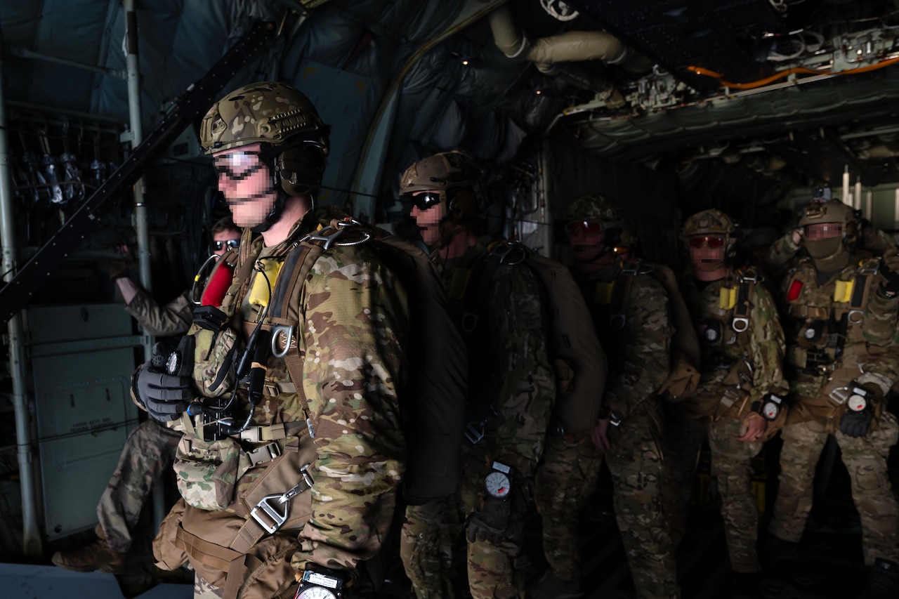 Green Berets line up to jump out on aircraft.