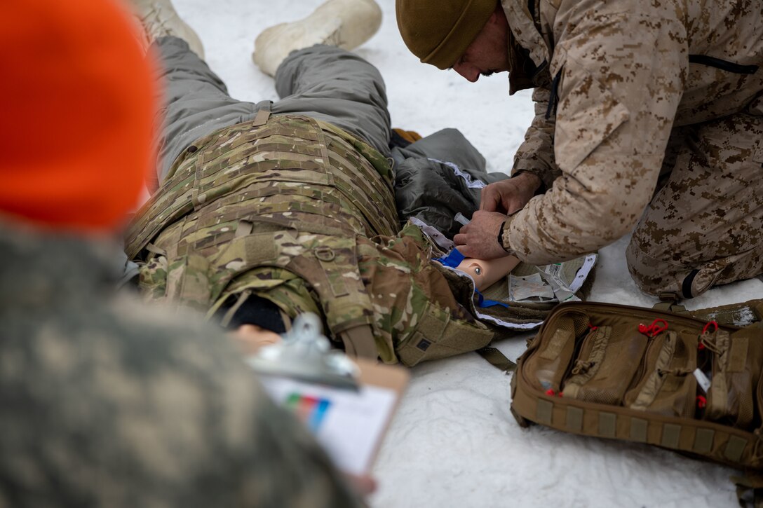 U.S. Navy HMC Peter Harding, a hospital corpsman with 1st Marine Division, I Marine Expeditionary Force, demonstrates Tactical Combat Casualty Care (TCCC) under arctic conditions to a joint-service delegation during Distinguished Visitor’s (DV) Day as part of exercise Arctic Edge 2024 (AE24) at Joint Base Elmendorf-Richardson, Alaska, March 4, 2024. The delegation visited and toured Camp Mad Bull, a site conducting several medical experiments in an arctic environment utilizing freeze dried plasma, portable oxygen generators, hypothermia prevention devices, core temperature monitors and more. AE24 DV Day fostered dynamic discussions among military, government, and academic leaders on arctic homeland defense, later featuring site visits, demonstrations, and presentations. Arctic Edge 2024 is a U.S. Northern Command-led homeland defense exercise demonstrating the U.S. military’s capabilities in extreme cold weather, joint force readiness, and U.S. military commitment to mutual strategic security interests in the arctic region. (U.S. Marine Corps photo by Lance Cpl. Madisyn Paschal)