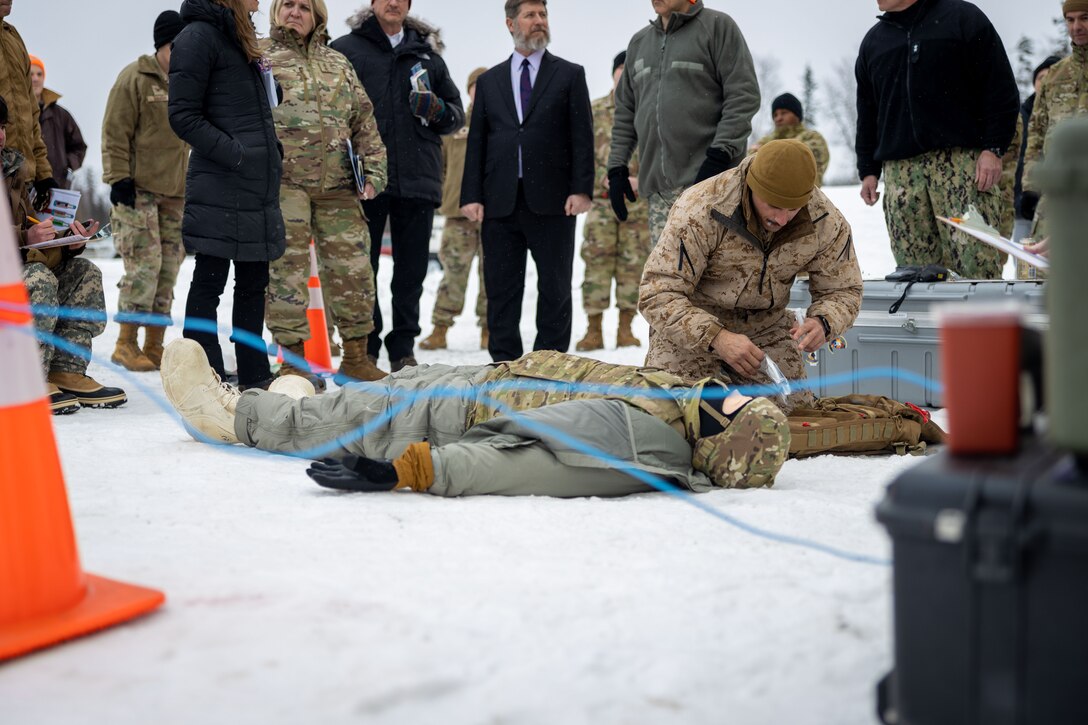 U.S. Navy HMC Peter Harding, a hospital corpsman with 1st Marine Division, I Marine Expeditionary Force, demonstrates Tactical Combat Casualty Care (TCCC) under arctic conditions to a joint-service delegation during Distinguished Visitor’s (DV) Day as part of exercise Arctic Edge 2024 (AE24) at Joint Base Elmendorf-Richardson, Alaska, March 4, 2024. The delegation visited and toured Camp Mad Bull, a site conducting several medical experiments in an arctic environment utilizing freeze dried plasma, portable oxygen generators, hypothermia prevention devices, core temperature monitors and more. AE24 DV Day fostered dynamic discussions among military, government, and academic leaders on arctic homeland defense, later featuring site visits, demonstrations, and presentations. Arctic Edge 2024 is a U.S. Northern Command-led homeland defense exercise demonstrating the U.S. military’s capabilities in extreme cold weather, joint force readiness, and U.S. military commitment to mutual strategic security interests in the arctic region. (U.S. Marine Corps photo by Lance Cpl. Madisyn Paschal)