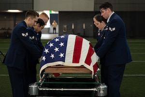 U.S. Air Force Airman 1st Class Ian Parker renders a salute to the American flag during a full honors funeral demonstration.