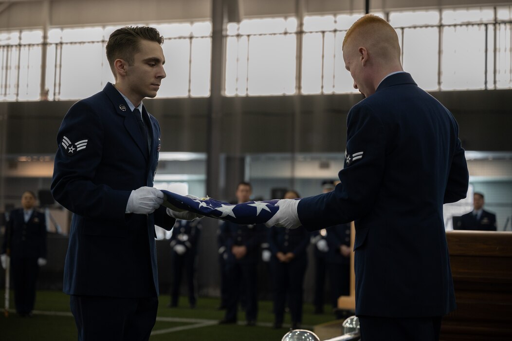 Airmen fold the American flag during a full honors funeral demonstration at Eielson Air Force Base, Alaska.
