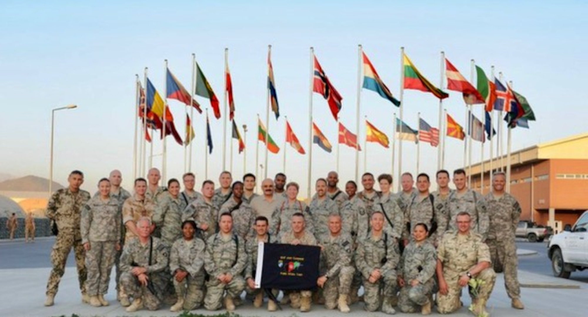 U.S. Air Force retired Tech. Sgt. Daylena Ricks, photojournalist, poses for a group photo with members of the International Security Assistance Force (ISAF) at Bagram Air Base, Afghanistan in 2010.