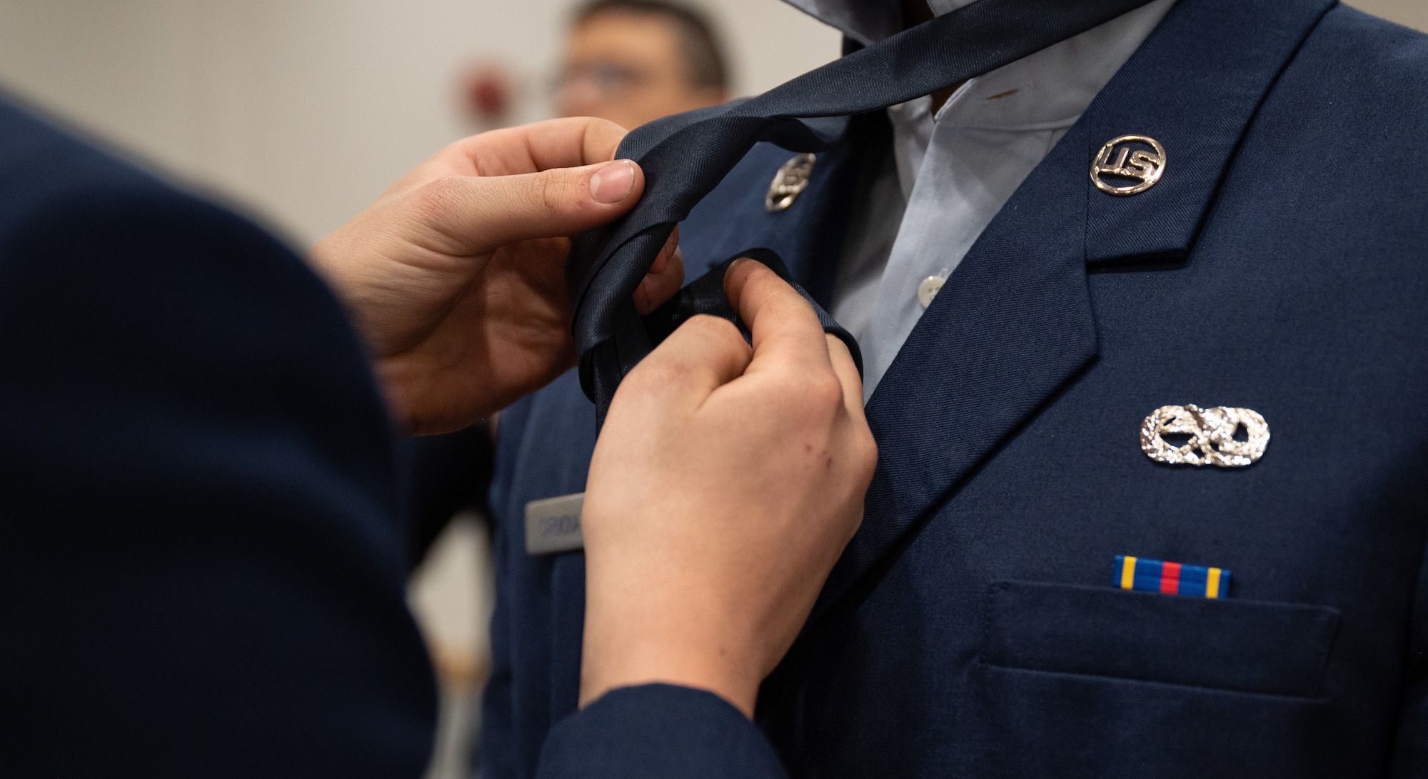 U.S. Air Force Airman 1st Class Warren Friessen, 36th Fighter Squadron weapons load crew member, left, adjusts a tie on Airman 1st Class David Carmona, 51st Munitions Squadron aircraft armament systems specialist, at Osan Air Base, Republic of Korea, March 5, 2024. The Airmen were preparing for a dress uniform inspection during the First Term Enlisted Course, a course that helps them transition to a mission-oriented mindset after technical training. The precision instilled in the 51st Fighter Wing Airmen when preparing their uniforms reflects the precision they demonstrate when executing their daily mission. (U.S. Air Force photo by Senior Airman Brittany Russell)