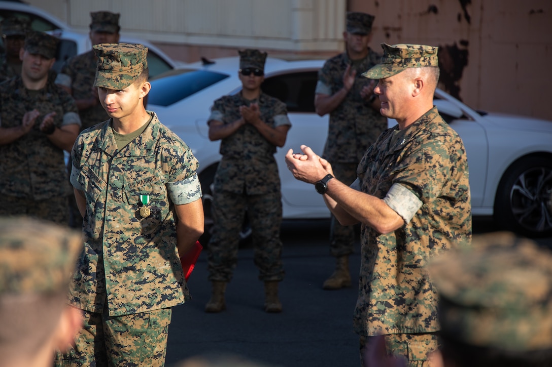 U.S. Marine Corps Lance Cpl. Kayden Cardona, aircraft maintenance support equipment electrician with Marine Aviation Logistics Squadron (MALS) 24, Marine Aircraft Group (MAG) 24, 1st Marine Aircraft Wing (MAW) receives an award from Col. William Heiken, commanding officer of MAG-24, 1st MAW at Marine Corps Air Station Kaneohe Bay, Hawaii, March 1, 2024. Cardona was awarded the Navy and Marine Corps Commendation Medal for lifesaving actions. (U.S. Marine Corps photo by Lance Cpl. Logan Beeney)