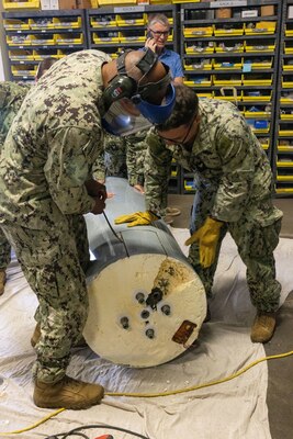 Chief Construction Electrician Trayvosier Roddy, left, and Construction Electrician 2nd Class Skylar Knight, both assigned to Naval Facilities Engineering Systems Command Hawaii, dismantle a water heater at the Seabee Warehouse on Joint Base Pearl Harbor-Hickam (JBPHH), Hawaii, Feb. 29, 2024. Dismantling the water heater is part of a Navy Region Hawaii investigation into potential causes for low-level detections of Total Petroleum Hydrocarbons.