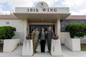 A group stand in front of the 18th Wing HQ.