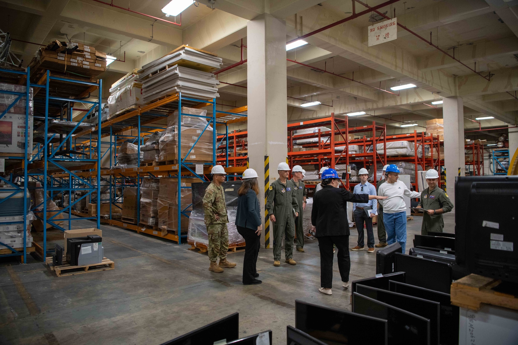 A group stands and talks in a warehouse.