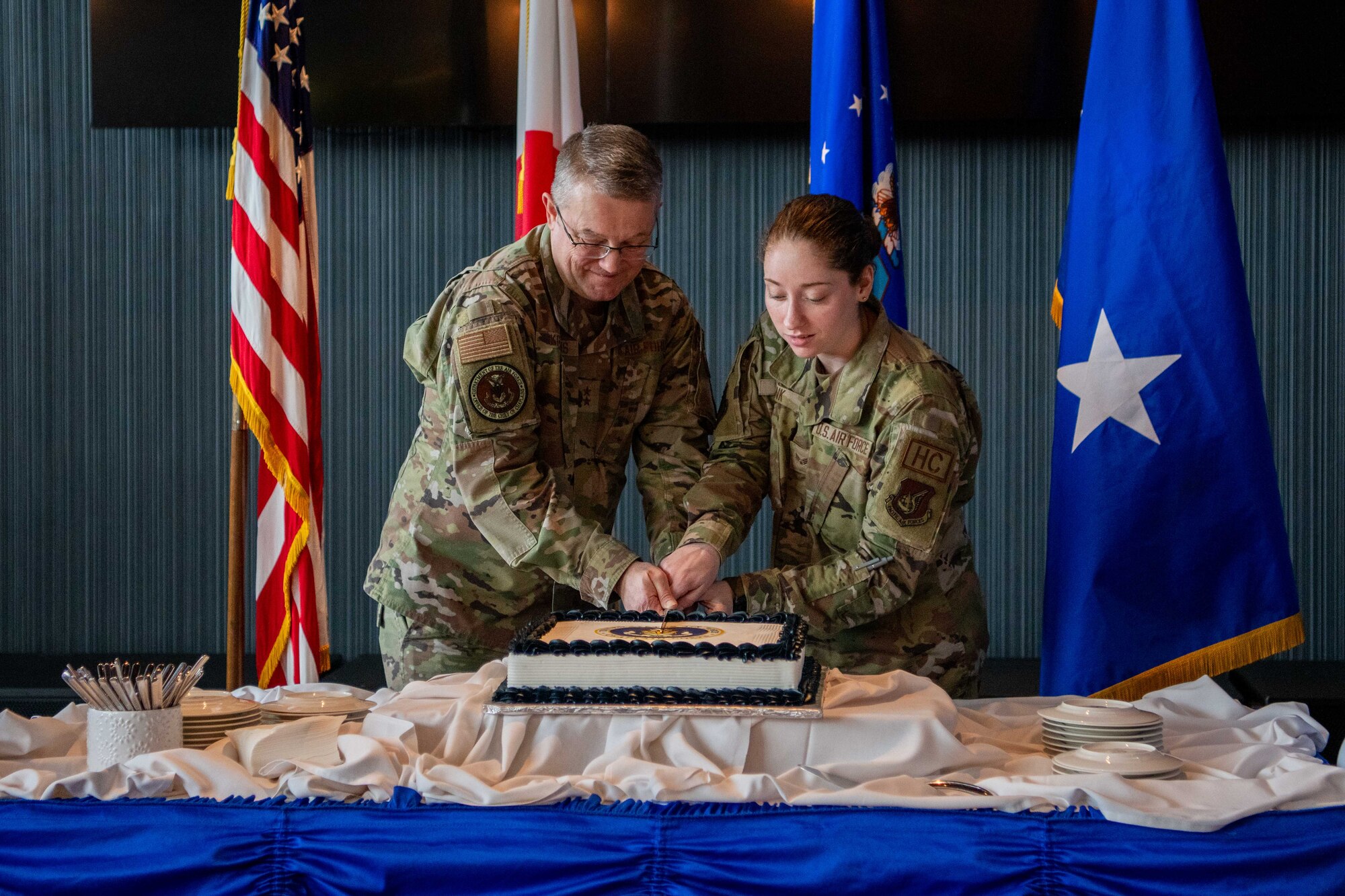 Two Airmen cut a cake.