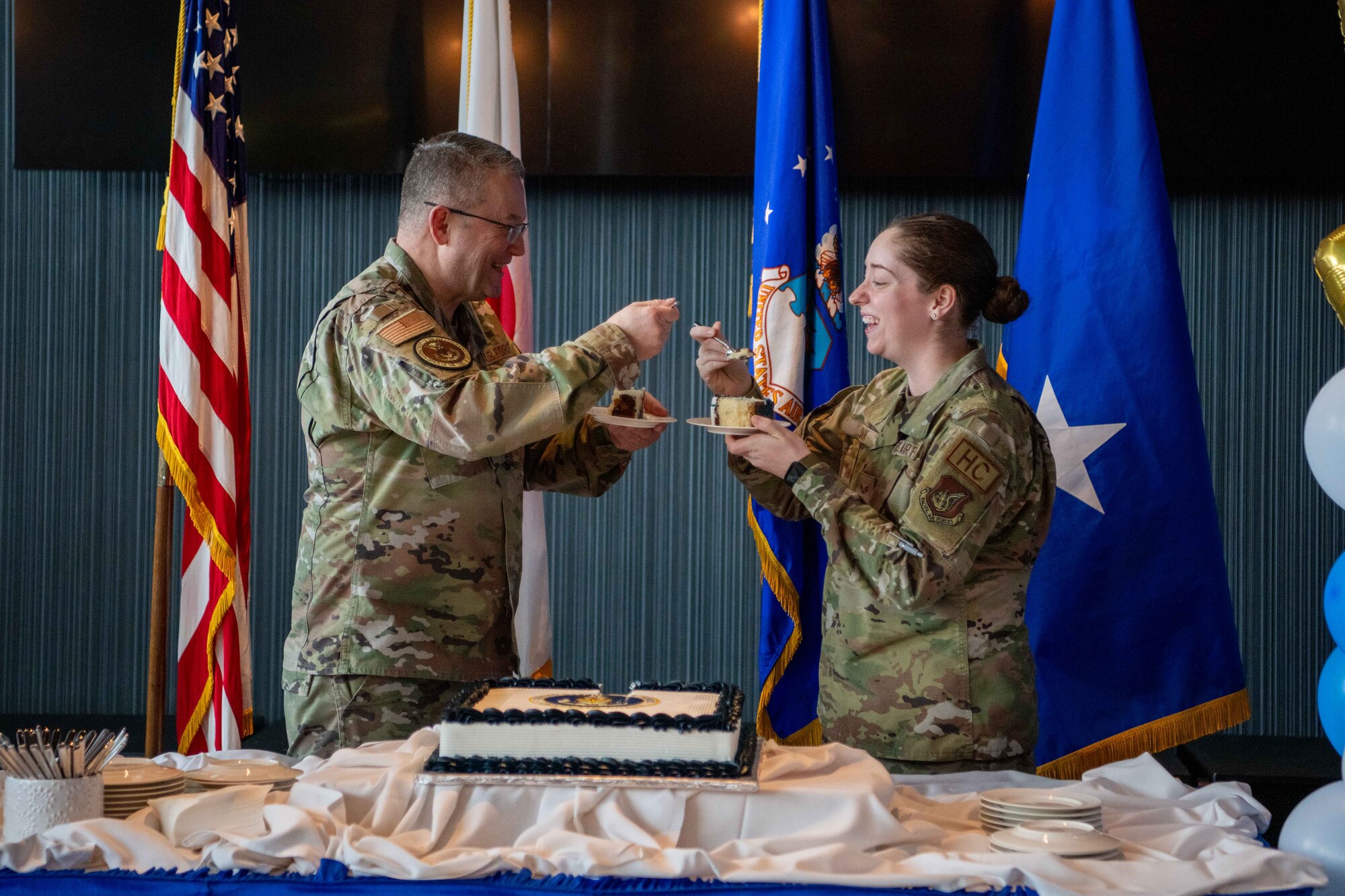 Two Airmen cheers with cake.