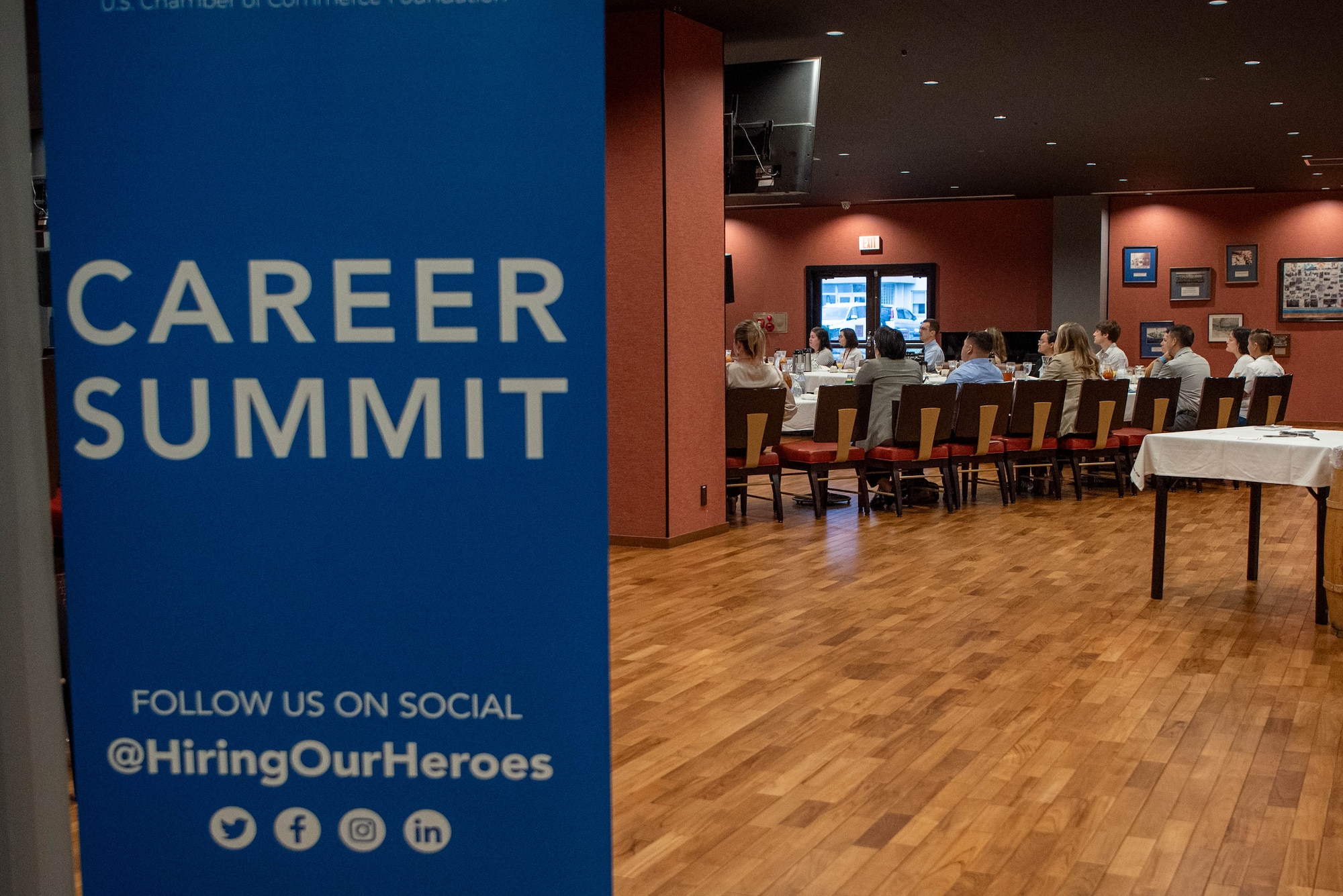 A group sit and watch something with a sign that reads 'career summit'