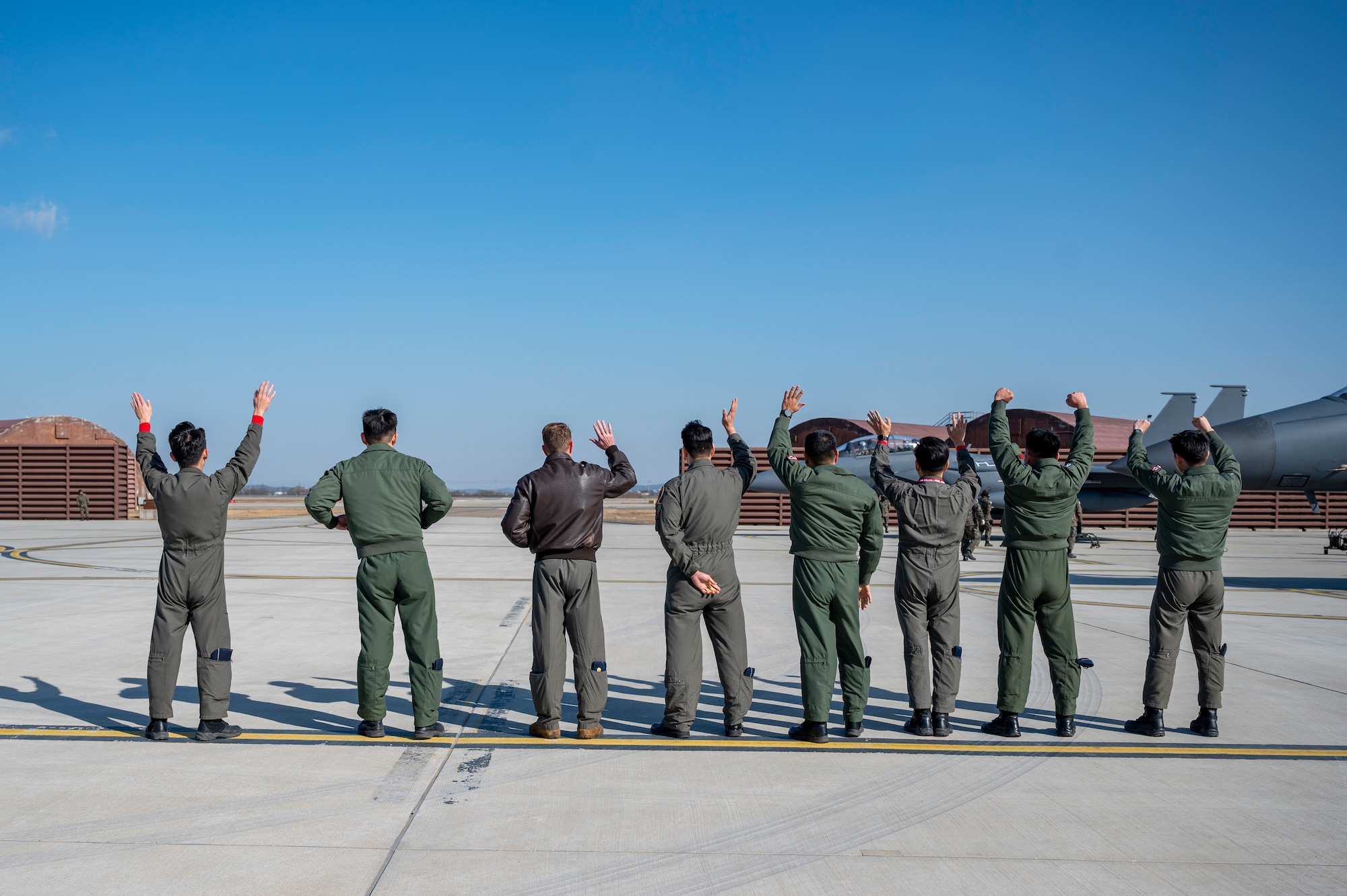 Service members from the U.S. Air Force and the Republic of Korea Air Force wave to ROKAF pilots as they depart after Buddy Squadron 24-2 at Osan Air Base, Republic of Korea, March 8, 2024. The Buddy Squadron Program allows for bilateral unification, giving more opportunity to train together and ensure lethality and readiness of pilots. The Buddy Squadron Program fosters objective-based training and improves interoperability between the U.S. and ROKAF fighter squadrons. (U.S. Air Force photo by Senior Airman Kaitlin Frazier)