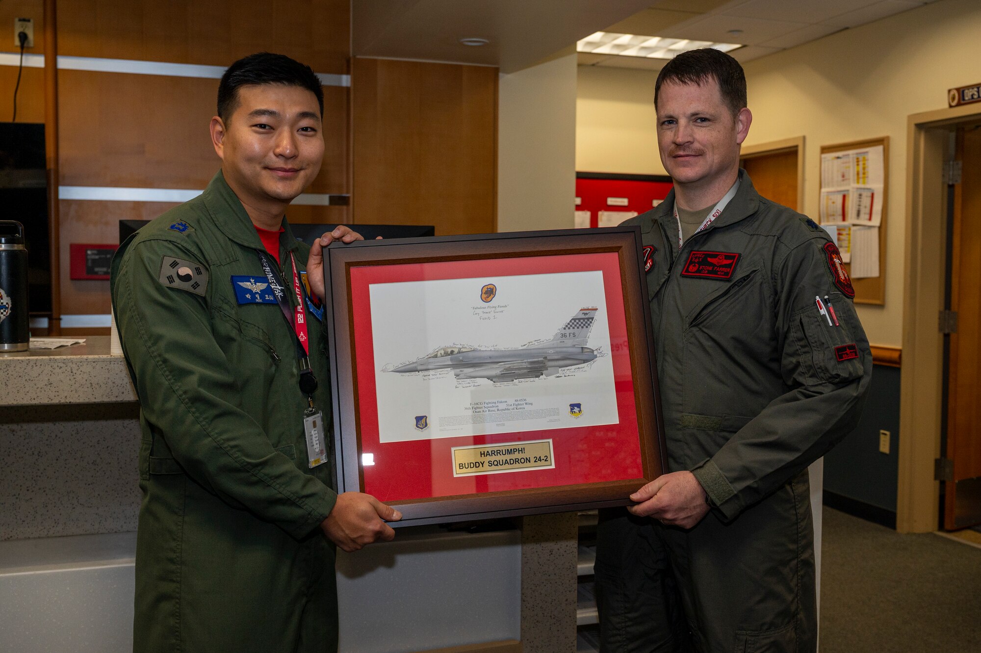 U.S. Air Force Lt. Col. Farrer, 36th Fighter Squadron commander, presents a plaque to Republic of Korea Air Force Maj. Youngdo Park, 122nd FS vice commander, closing Buddy Squadron 24-2 at Osan Air Base Republic of Korea, March 8, 2024. ROKAF pilots assigned to the 122nd FS trained alongside the 36th FS assigned to Osan AB, and 35th FS assigned to Kunsan AB, ROK, during the week-long training event. The Buddy Squadron Program fosters objective-based training and improves interoperability between the U.S. and ROKAF fighter squadrons. (U.S. Air Force photo by Senior Airman Kaitlin Frazier)