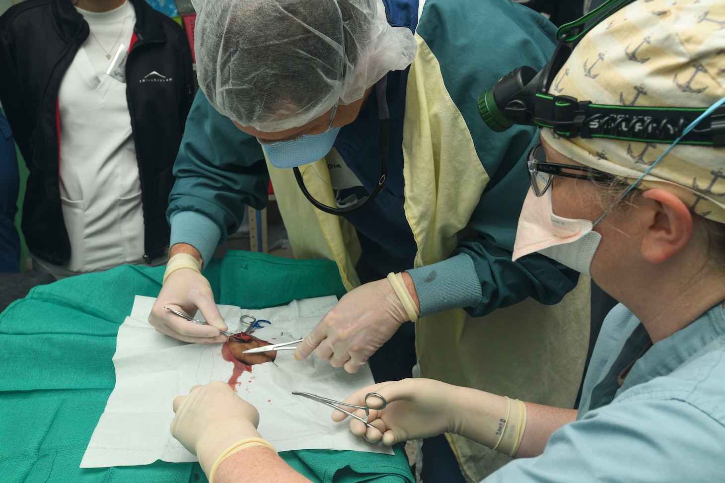 240227-N-FB730-1078 SAN PEDRO SULA, HONDURAS (Feb. 27, 2024) Surgeons with Expeditionary Medical Unit (EMU) 10 G remove stitches from a patient’s hand in the trauma bay at Hospital Nacional Mario Catarino Rivas, San Pedro Sula, Honduras on Feb. 27, 2024. In collaboration with joint forces and the host nation, EMU 10 G conducted its first Global Health Engagement in Honduras enhances expeditionary core skills and exchanges knowledge with Honduran healthcare professionals in a limited resource environment. (U.S. Navy photo by Mass Communication Specialist 2nd Class Justin Woods)