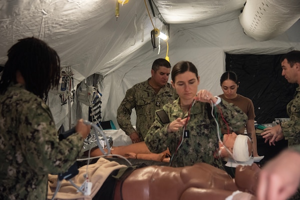 Medical personnel from Expeditionary Medical Facility 150 Alpha treat a simulated casualty on Feb. 27, 2024, aboard Naval Expeditionary Medical Training Institute, Marine Corps Base Camp Pendleton. The simulated patient was received from 1st Medical Battalion as EMF 150 Alpha was providing the Role 3 medical capability during Med. Bn.’s Marine Corps Combat Readiness Evaluation. During the weeklong exercise, EMF 150 Alpha received, treated, tracked, and medically evacuated 76 patients.