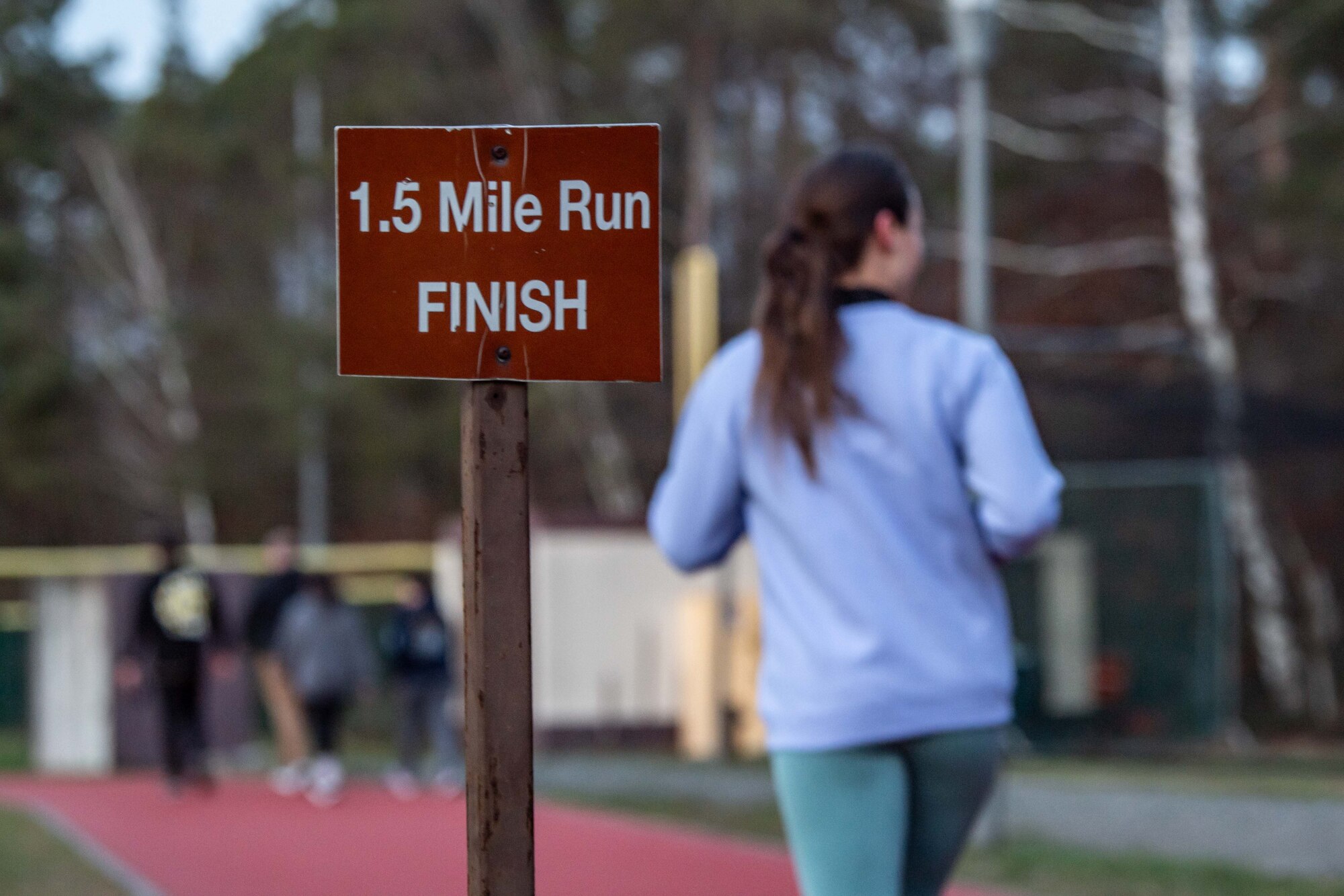 A KMC member runs past a sign marking the finish line on a track