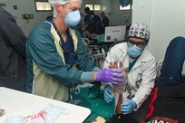 240227-N-FB730-1113 SAN PEDRO SULA, HONDURAS (Feb. 27, 2024) Capt. Bradley Deafenbaugh, left, an orthopedic surgeon with Navy Medicine Readiness and Training Command Portsmouth, and Michael Ortega, right, a Honduran medical student, apply a cast to a patient’s hand in the trauma bay at Hospital Nacional Mario Catarino Rivas, San Pedro Sula, Honduras on Feb. 27, 2024. In collaboration with joint forces and the host nation, Expeditionary Medical Unit 10 G conducted its first Global Health Engagement in Honduras enhances expeditionary core skills and exchanges knowledge with Honduran healthcare professionals in a limited resource environment. (U.S. Navy photo by Mass Communication Specialist 2nd Class Justin Woods)