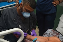 240227-N-FB730-1108 SAN PEDRO SULA, HONDURAS (Feb. 27, 2024) Hospital Corpsman 3rd Class Leonard Brooks, a radiation health technician, inserts an I.V. into the arm of a patient in the trauma bay at Hospital Nacional Mario Catarino Rivas, San Pedro Sula, Honduras on Feb. 27, 2024. In collaboration with joint forces and the host nation, EMF-Kilo conducted its first Global Health Engagement to enhance expeditionary core skills and knowledge exchange with Honduran healthcare professionals in a limited resource environment. (U.S. Navy photo by Mass Communication Specialist 2nd Class Justin Woods)