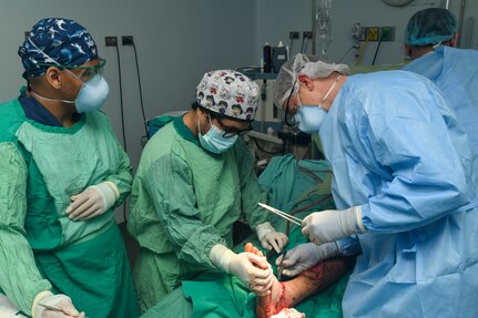 240227-N-FB730-1064 SAN PEDRO SULA, HONDURAS (Feb. 27, 2024) Michael Ortega, left, a Honduran medical student, assists Capt. Bradley Deafenbaugh, right, an orthopedic surgeon with Navy Medicine Training Command Portsmouth, sutures a patient’s foot in an operating room at Hospital Nacional Mario Catarino Rivas, San Pedro Sula, Honduras on Feb. 27, 2024. In collaboration with joint forces and the host nation, Expeditionary Medical Unit 10 G conducted its first Global Health Engagement in Honduras enhances expeditionary core skills and exchanges knowledge with Honduran healthcare professionals in a limited resource environment. (U.S. Navy photo by Mass Communication Specialist 2nd Class Justin Woods) (Disclaimer: Graphic imagery of human anatomy)