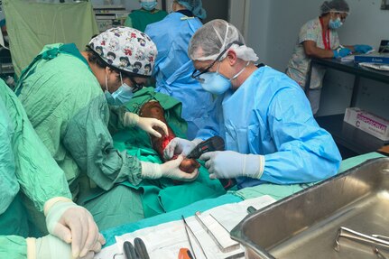 240227-N-FB730-1050 SAN PEDRO SULA, HONDURAS (Feb. 27, 2024) Michael Ortega, left, a Honduran medical student, assists Capt. Bradley Deafenbaugh, right, an orthopedic surgeon with Navy Medicine Readiness and Training Command Portsmouth, drill a wire into the foot of a patient in an operating room at Hospital Nacional Mario Catarino Rivas, San Pedro Sula, Honduras on Feb. 27, 2024. In collaboration with joint forces and the host nation, Expeditionary Medical Unit 10 G conducted its first Global Health Engagement in Honduras enhances expeditionary core skills and exchanges knowledge with Honduran healthcare professionals in a limited resource environment. (U.S. Navy photo by Mass Communication Specialist 2nd Class Justin Woods) (Disclaimer: Graphic imagery of human anatomy)