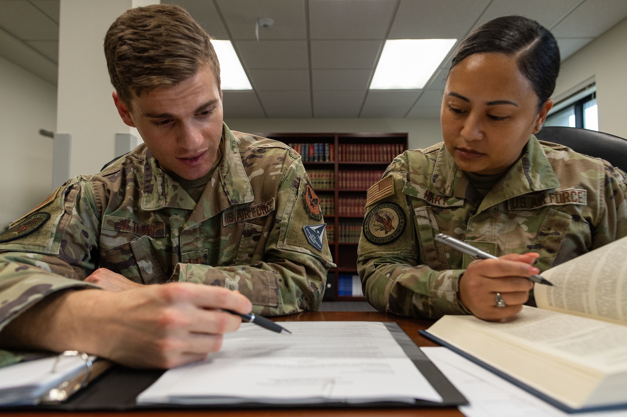 U.S. Air Force Capt. Cole Altman, left, Dover Area Defense Counsel, and U.S. Air Force Senior Airman Nicole Hart, right, Dover ADC defense paralegal, review legal case documents in their office on Dover Air Force Base, Delaware, March 6, 2024. Altman and Hart provide free representation to Airmen on matters ranging from the Air Force Office of Special Investigations and Security Forces investigations, administrative discharges, and court-martials. (U.S. Air Force photo by Roland Balik)