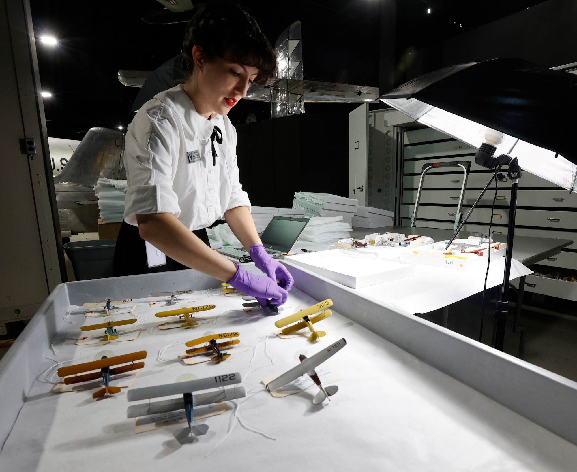 Conservator Sarah Gilcrease from the Collections Division at the National Museum of the U.S. Air Force inspects, catalogs and packs model aircraft from the Kettering Model Collection for shipping to the conservation firm ICA in Cleveland, Ohio. After the conservation process has been completed, the 624 model aircraft will be displayed in a new case in the museum's Kettering Hall in the Spring/Summer of 2025.