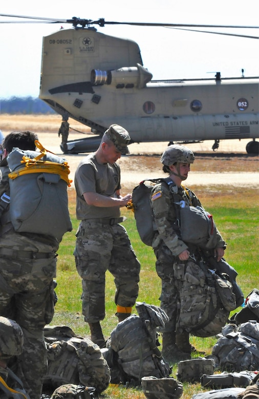 U.S. Army Reservists from the 404th Civil Air Battalion, Airborne, “chute-up,” and go through Jumpmaster Parachute Inspection prior to a scheduled Airborne operation at Joint Base McGuire-Dix-Lakehurst, N.J, April 14, 2023. Training support at U.S. Army Support Activity Fort Dix is meticulously tailored across three domains: virtual, live and constructive. (U.S. Army photo by Steven Roussel)