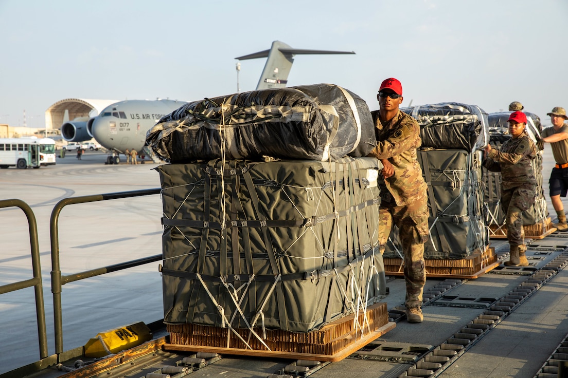 U.S. service members, assigned to the 165th QM BADS-A, Detachment 2, load humanitarian aid pallets rigged with parachutes inside of a C-17 Globemaster III, March 3, 2024. Army Parachute Riggers are specialized in aerial delivery of supplies, and built these bundles to support the safe drop of aid