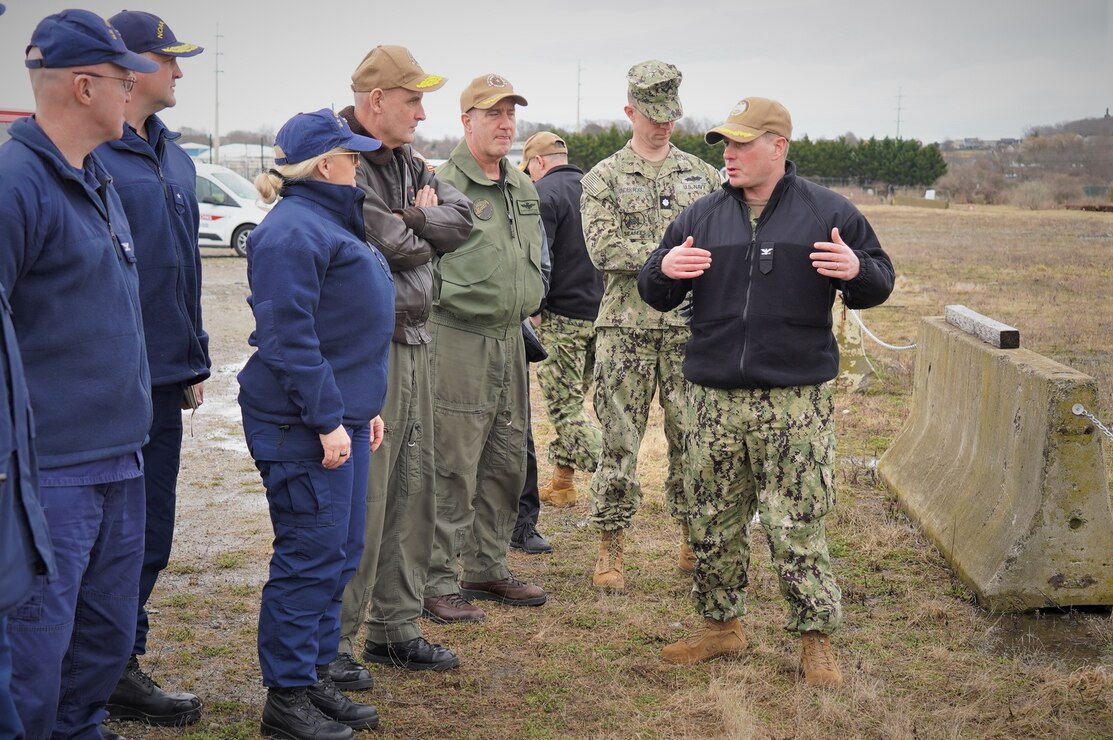 Capt. Henry Roenke (right), installation commanding officer, explains the Naval Station Newport waterfront projects and future footprint of the U.S. Coast Guard and National Oceanic and Atmospheric Association to RDML Wesley McCall, commander, Navy Region Mid-Atlantic, Coast Guard RADM Carola List, commander of Operational Logistics Command, NOAA RDML Chad Cary, deputy director, NOAA marine and aviation operations and other leaders during a visit March 7. The completed facilities are expected to be operational by 2028.