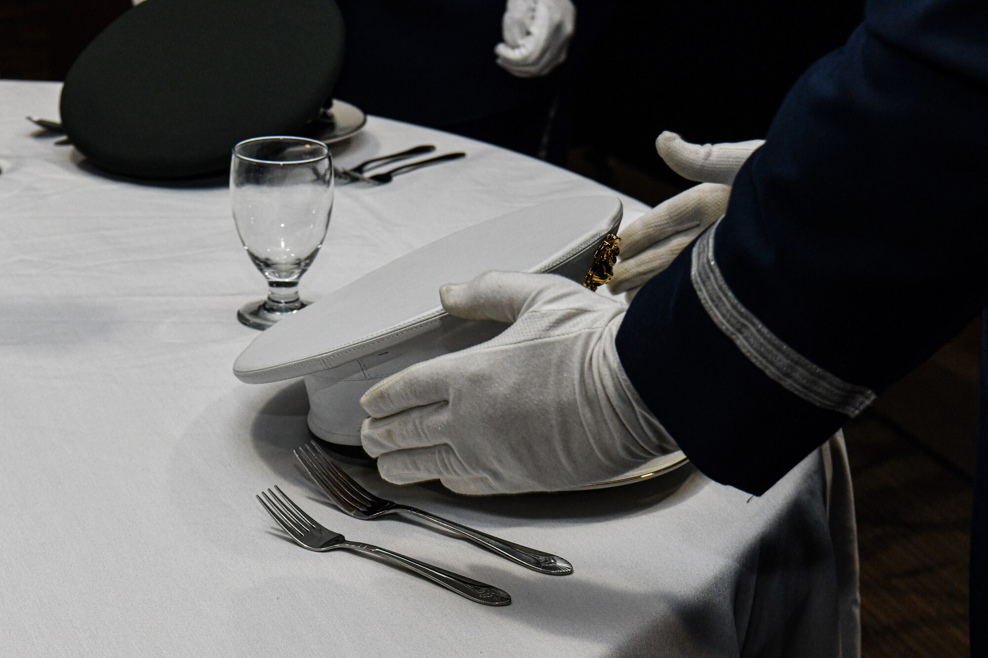 A member of the 910th Airlift Wing Base Honor Guard places the hat of a service member on the POW/MIA table during the 910th Airlift Wing’s annual award banquet, March 2, 2024, at Youngstown Air Reserve Station, Ohio.