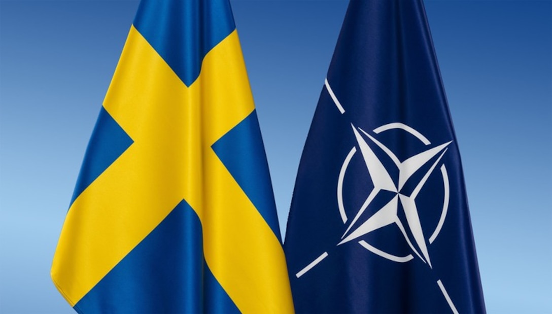 The Swedish flag is next to the NATO flag with a blue background.